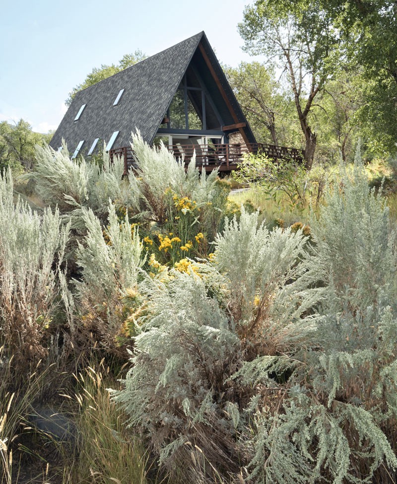 An A-frame house surrounded by plants in Heber, Utah.