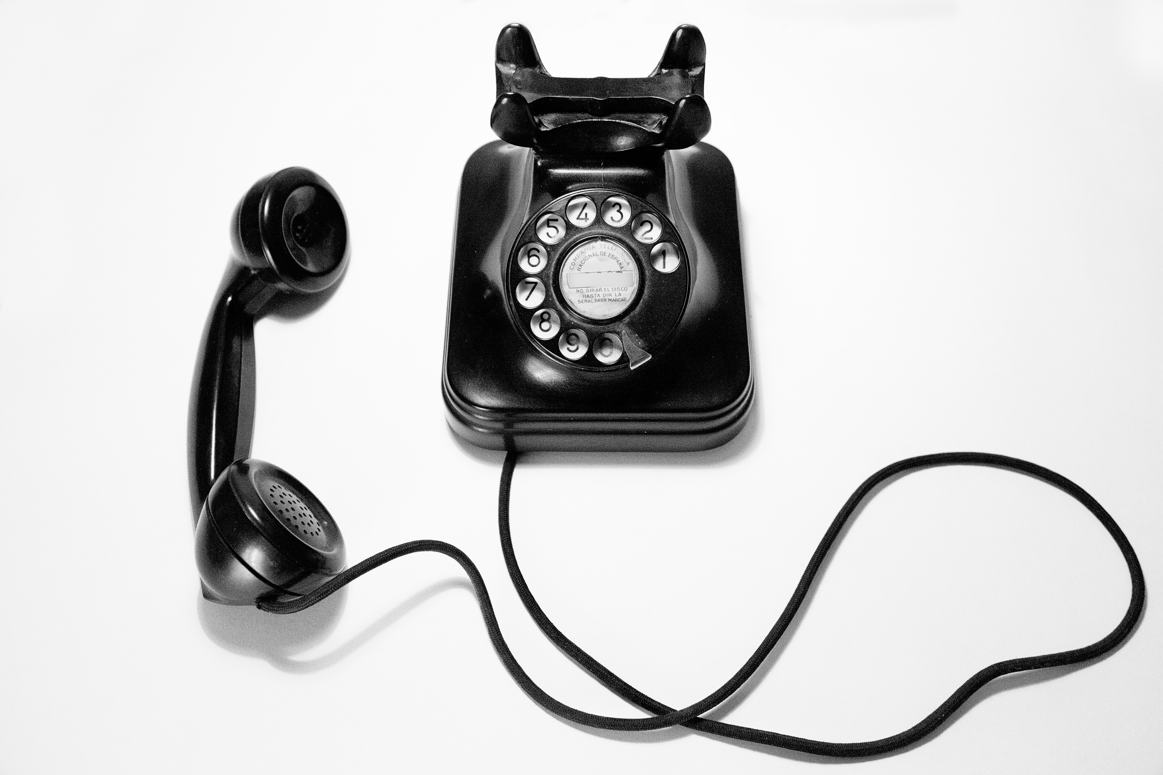 image of black rotary phone on a white background